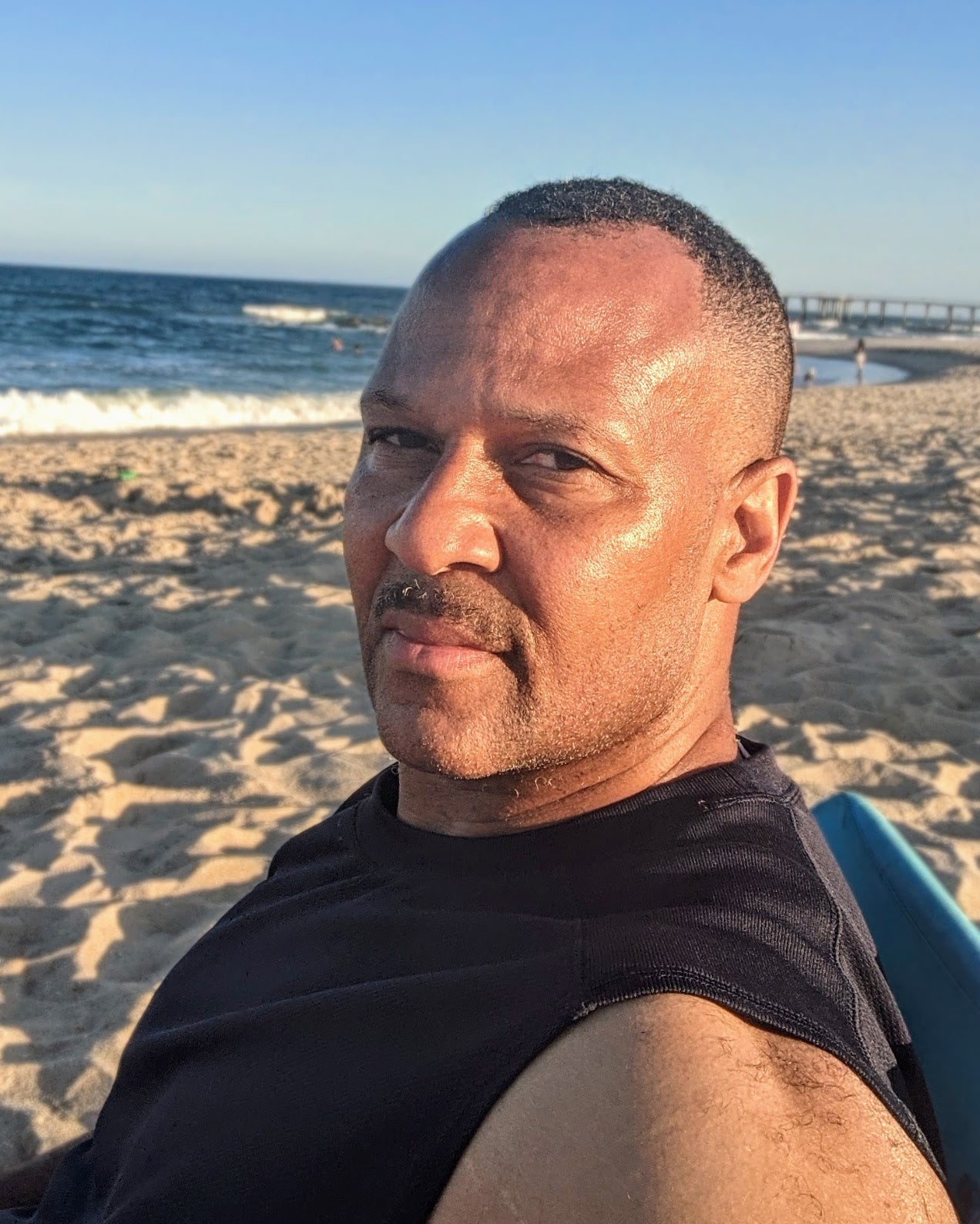 McLendon Bowden, Christian artist and co-pastor at Breakthrough in Christ Ministries, smiling at the beach — professional artist portrait for Gallery of Grace online art gallery